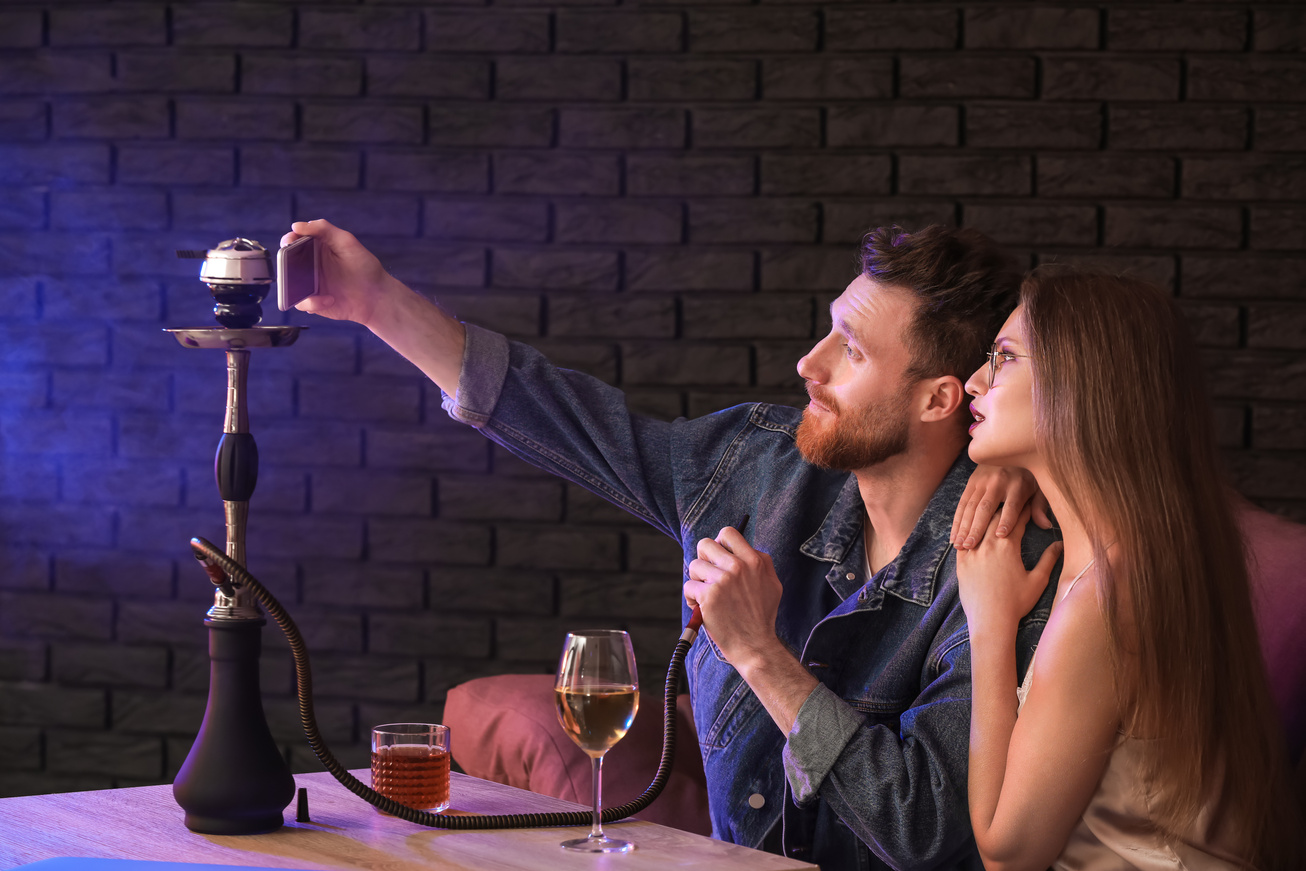 Young Couple Smoking Hookah in Cafe