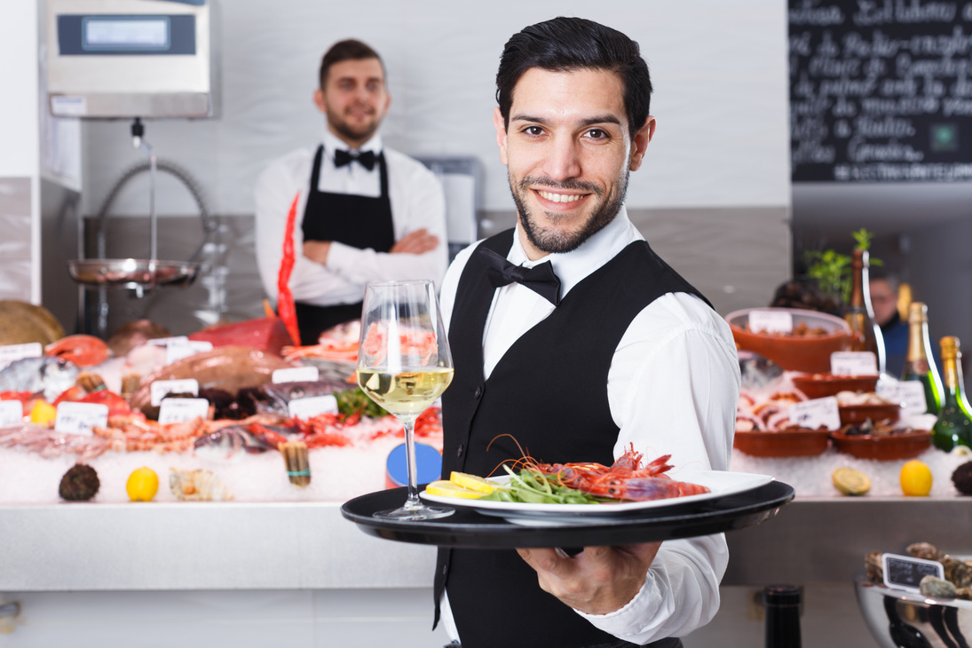 Waiter with serving tray in fish restaurant