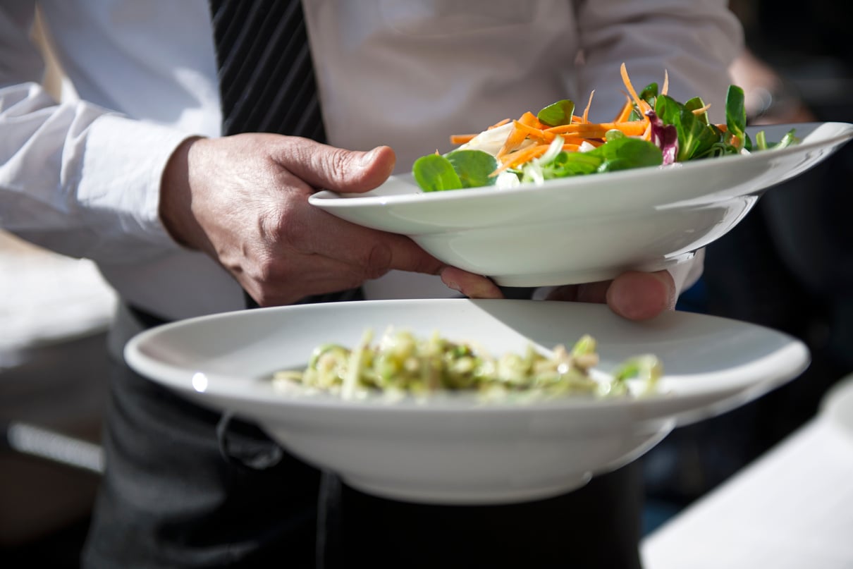 Waiter serving salad